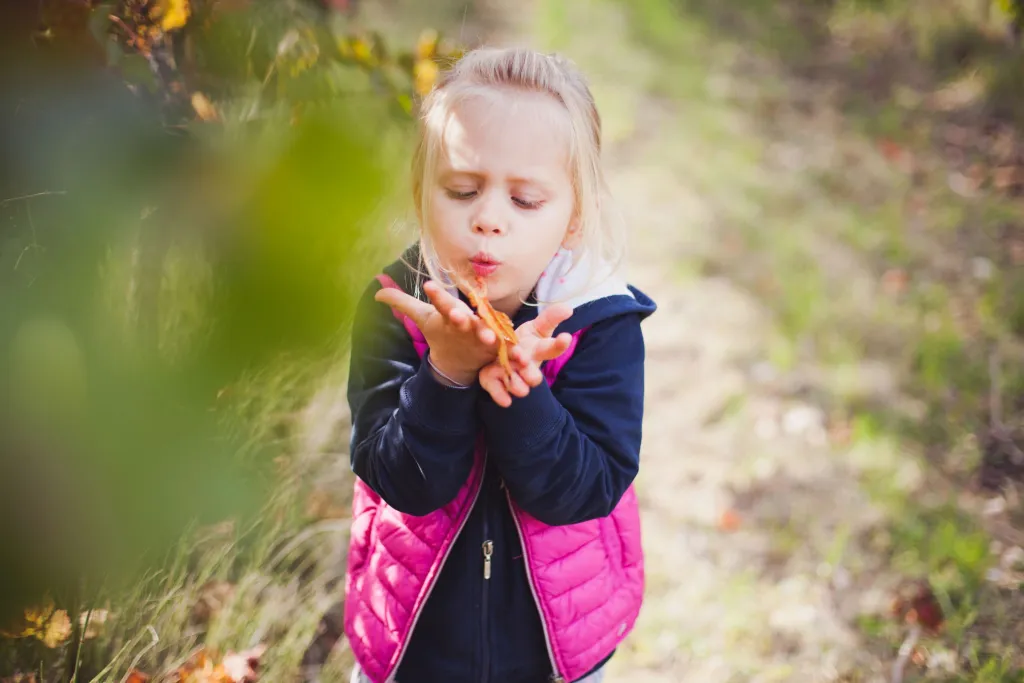 petite-fille-souffle-feuille-automne