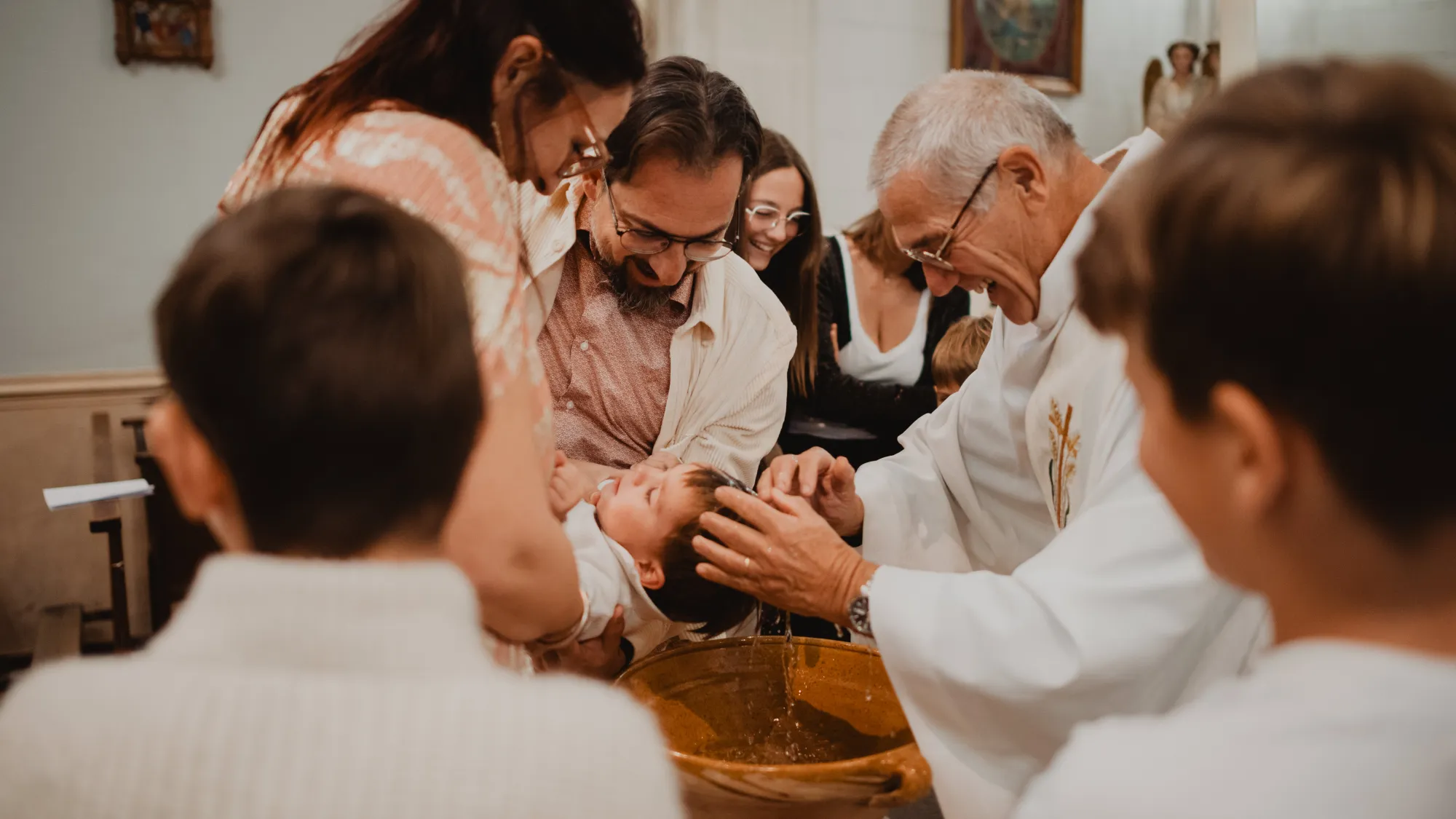 Baptême d’un bébé entouré de sa famille dans l’église de Villelaure