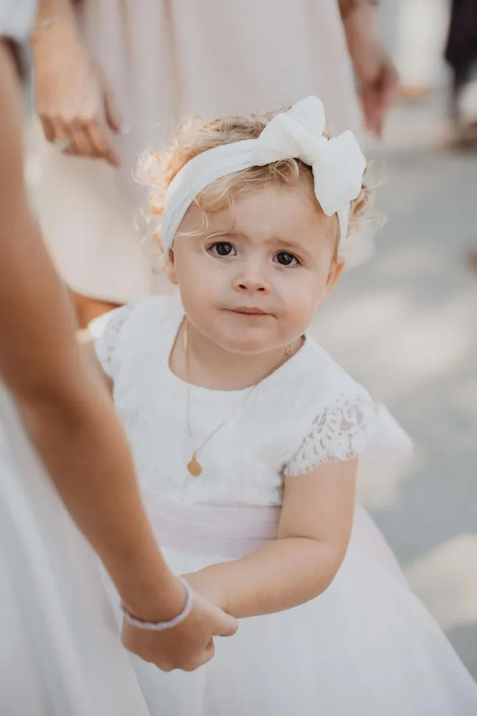 Petite fille en robe blanche le jour de son baptême