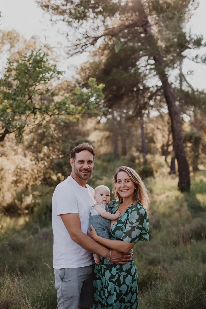 Parents portant leur bébé dans une pinède, séance famille nature en Provence