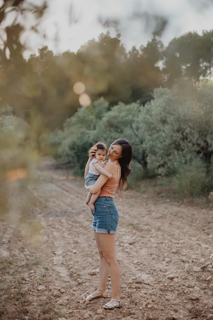 Maman portant son enfant sur un chemin de campagne