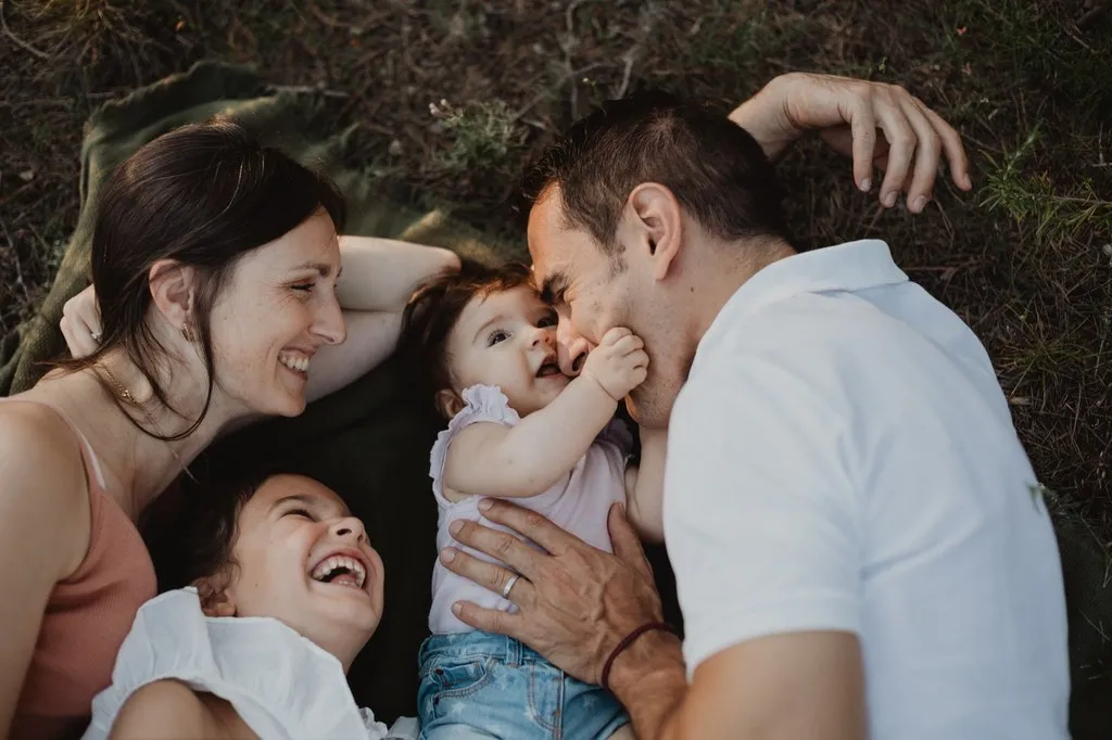 Parents et enfants allongés dans l’herbe, éclats de rire