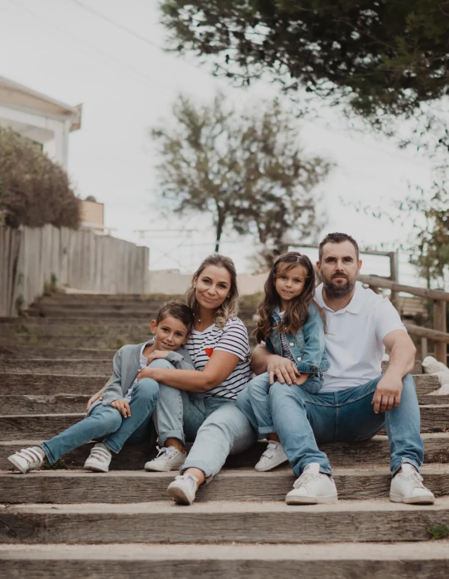 Famille assise sur un escalier de bord de mer