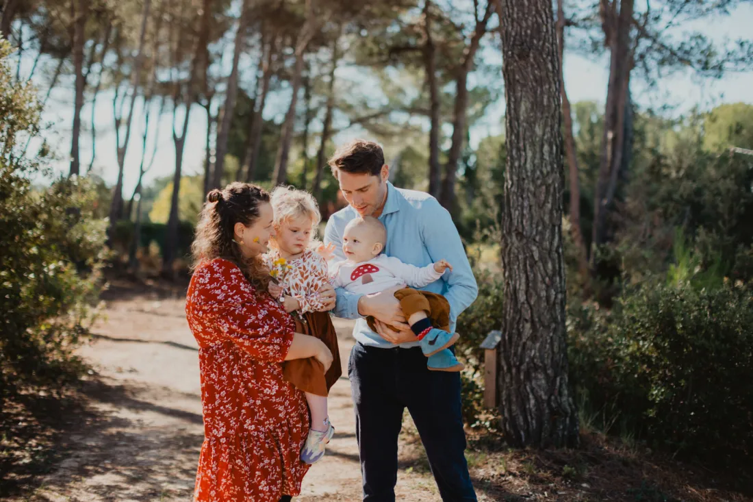 Famille avec deux jeunes enfants dans une pinède à Puyricard