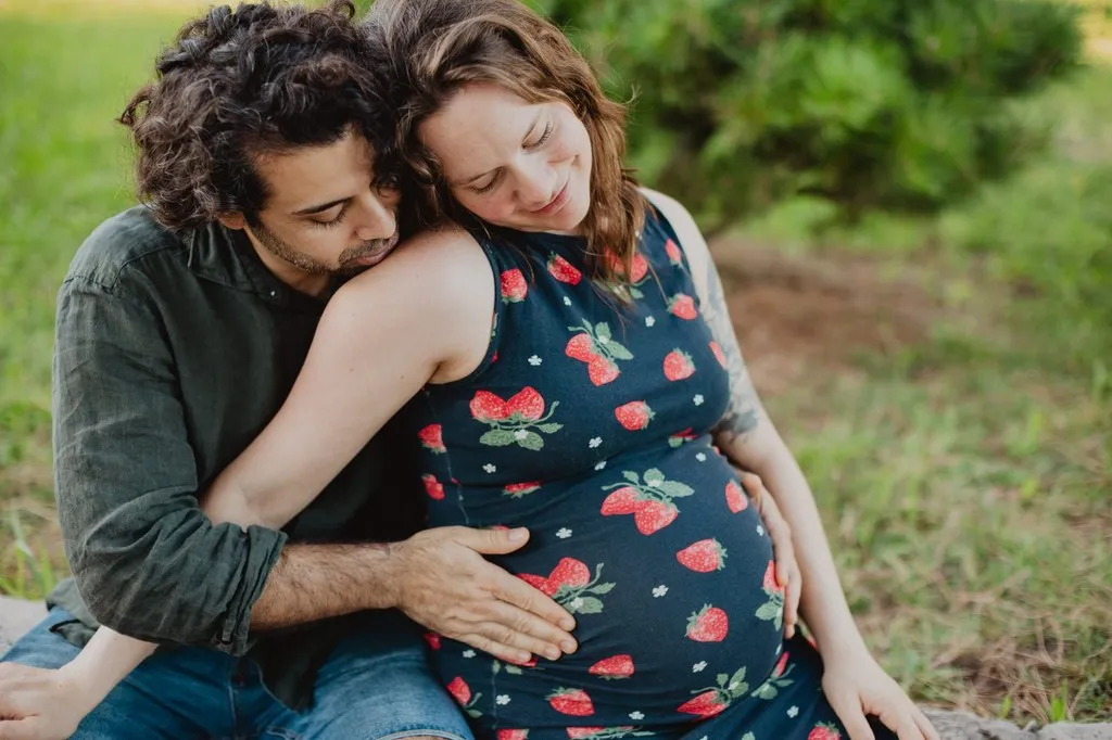 Futur papa enlaçant sa compagne enceinte