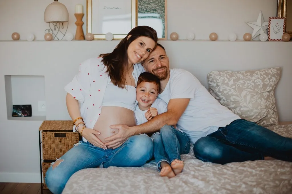 Séance grossesse à domicile, en famille sur le lit