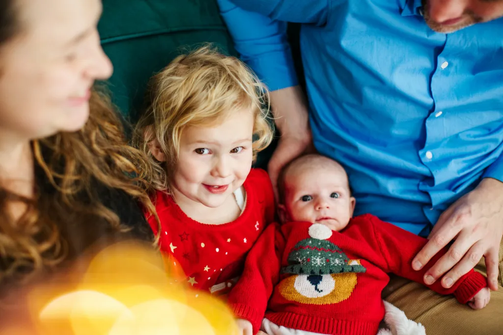 Enfants et parents devant le sapin, mini-séance de Noël à domicile