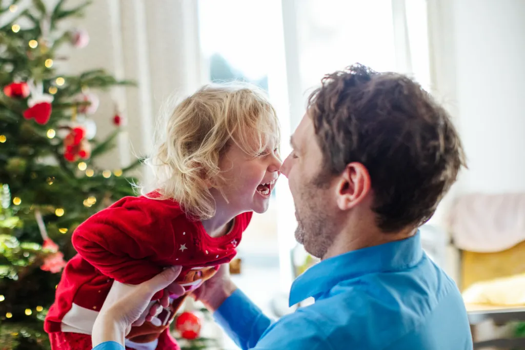 Parents et enfants riant au pied du sapin de Noël