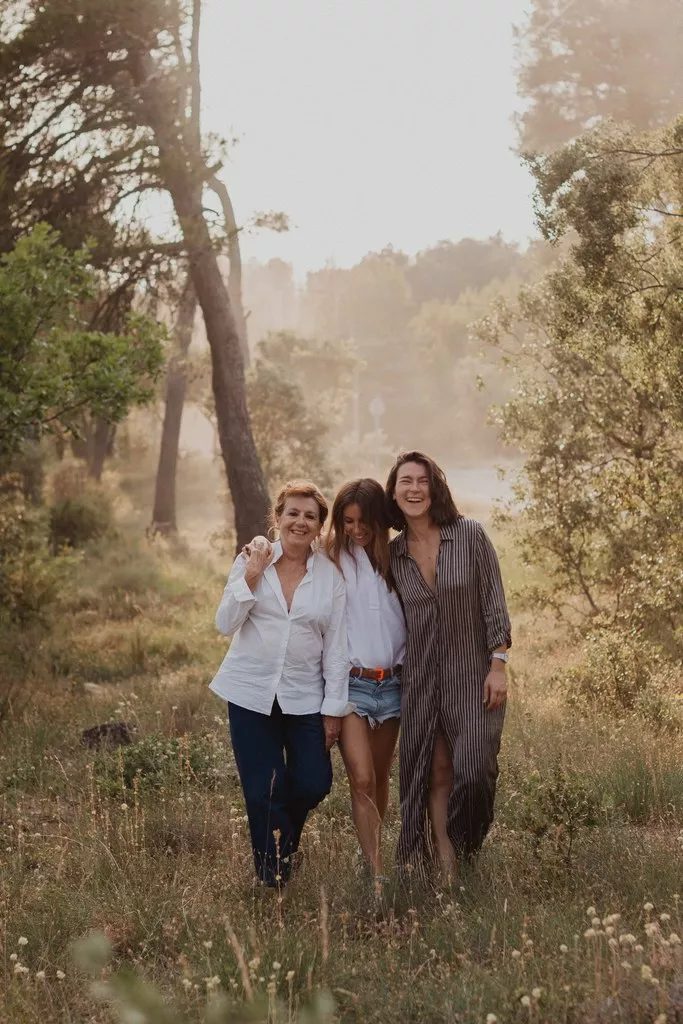 Une mère et ses deux filles marchant ensemble dans la nature lors d’une séance photo famille en Provence