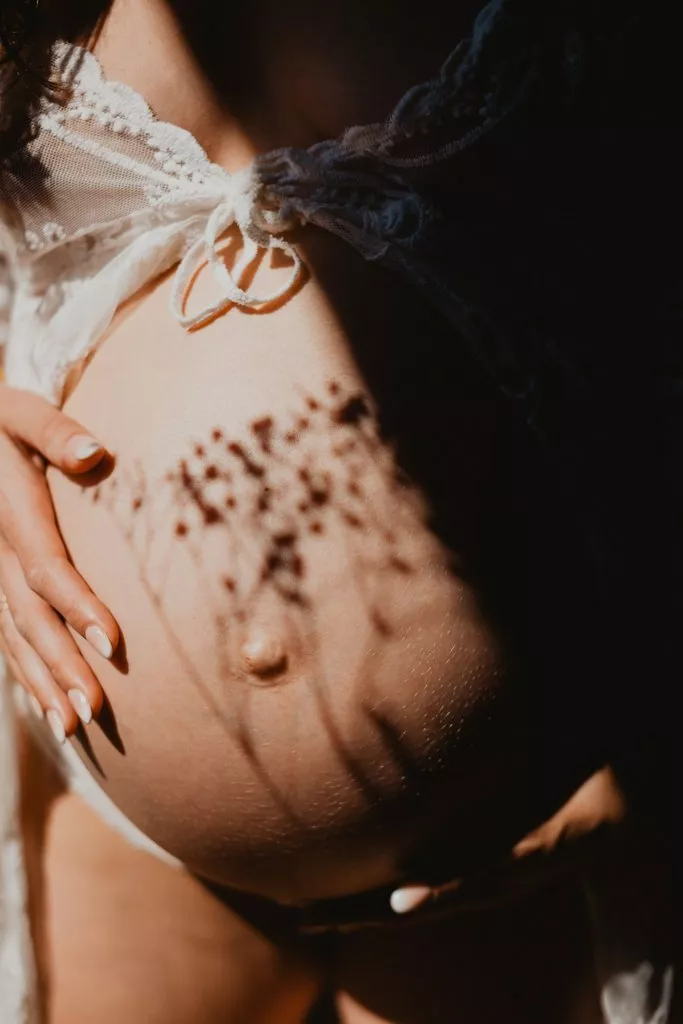 Ventre de femme enceinte photographié avec des jeux d’ombres et de lumière lors d’une séance grossesse à Meyreuil
